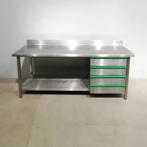 Taula d'acer inoxidable de segona mà amb lleixa inferior i 4 calaixos (200x70x92cm) en venda a cabauoportunitats.com