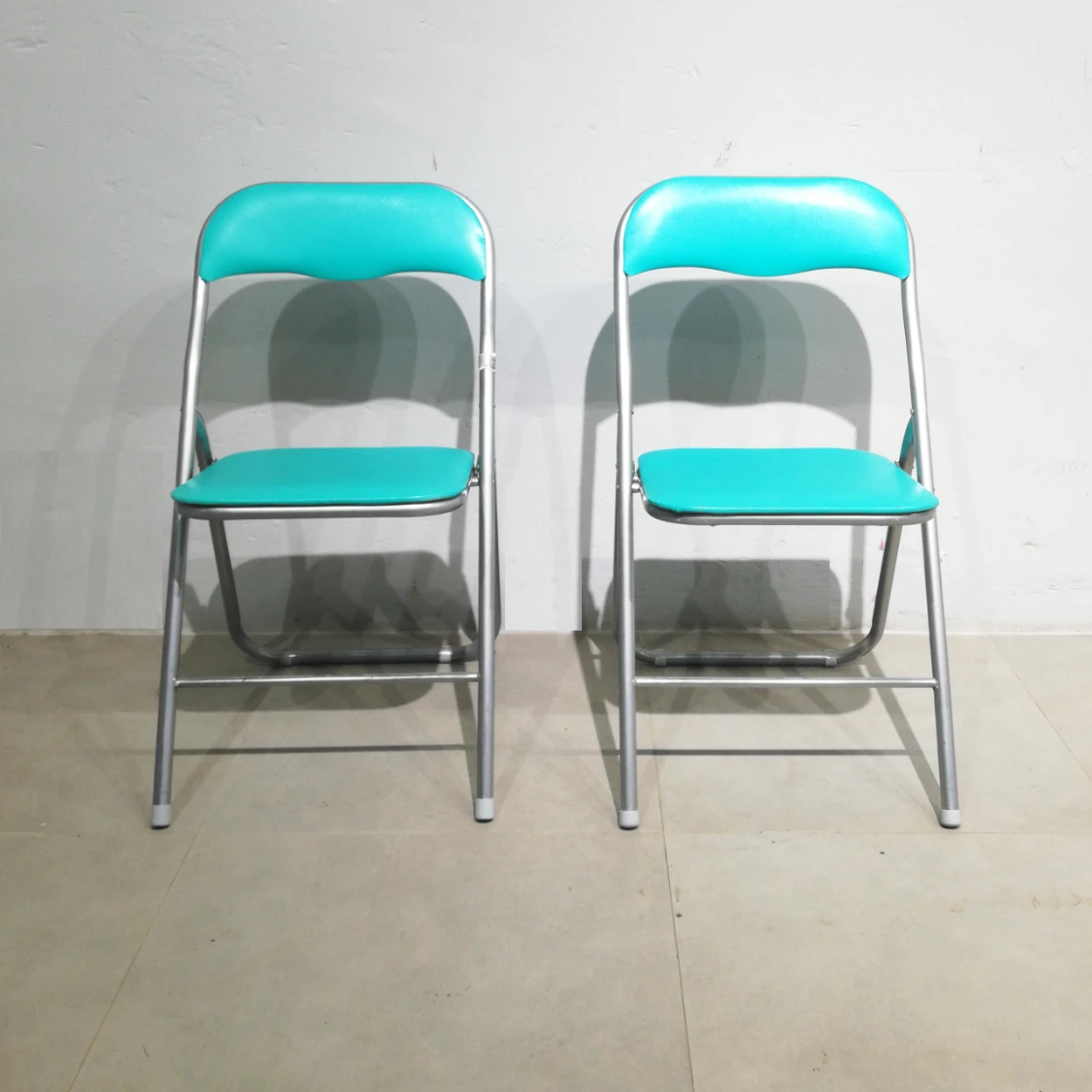 Cadira plegable amb entapissat verd (44x39x79cm) procedent d'una empresa en tancament