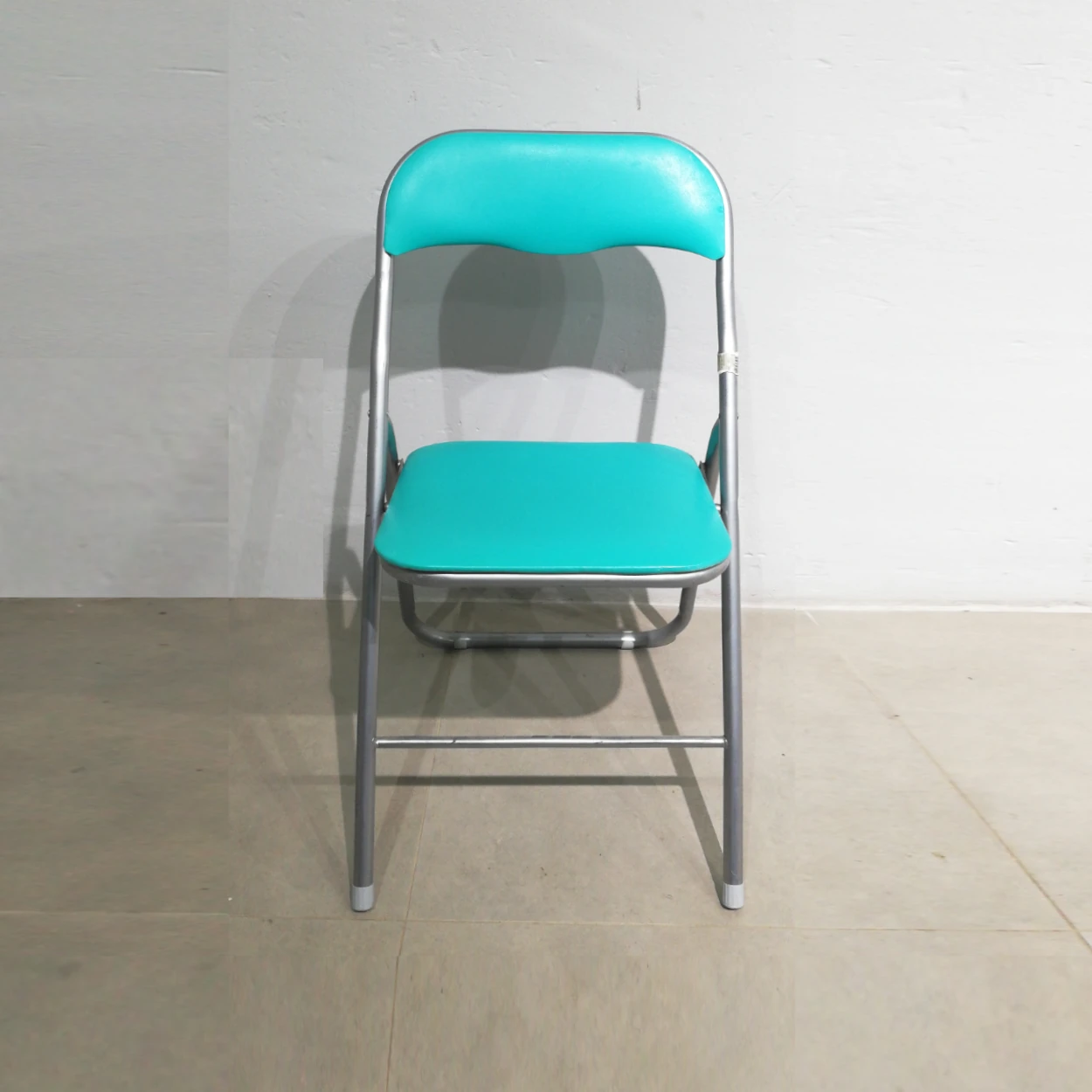 Cadira plegable amb entapissat verd (44x39x79cm) procedent d'una empresa en tancament