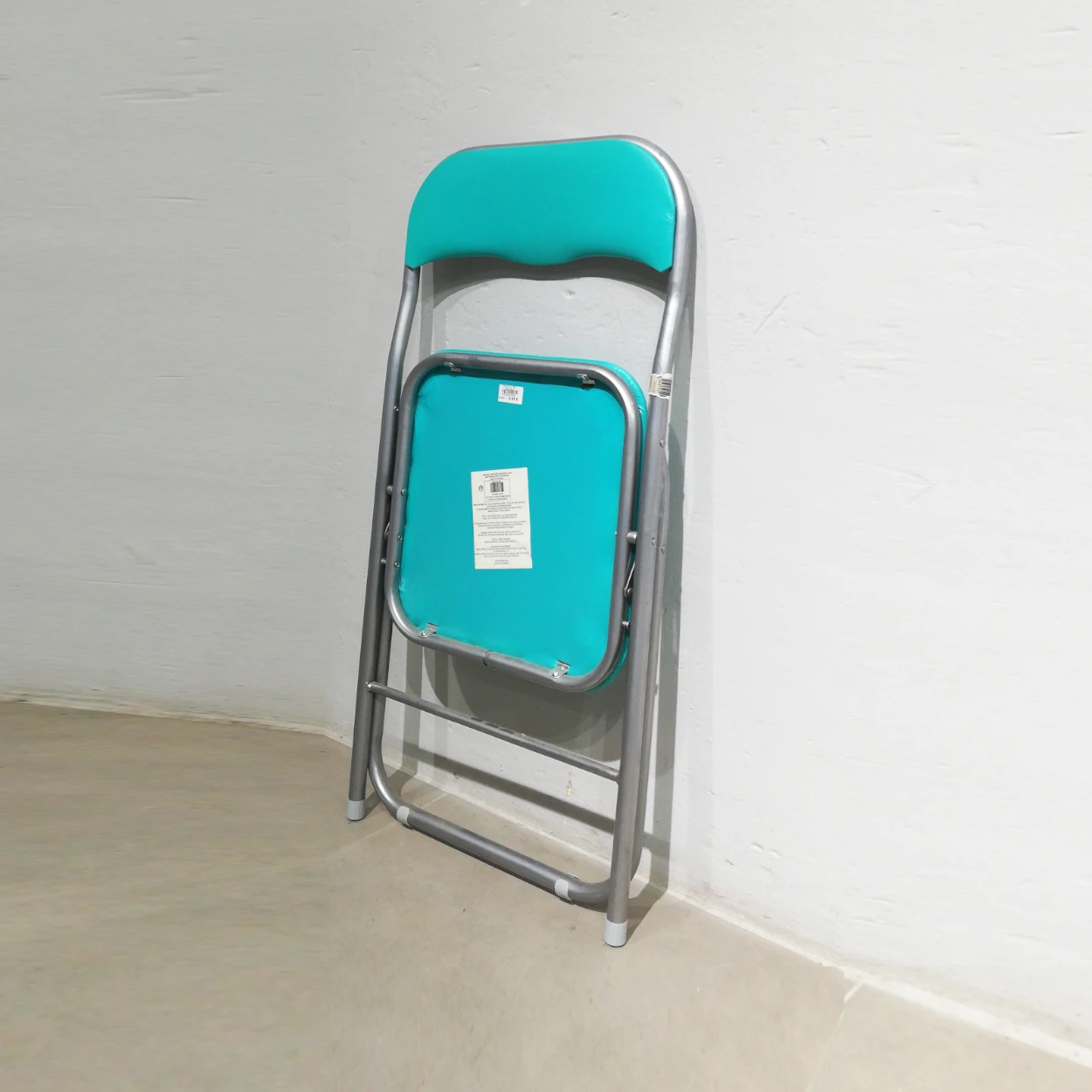 Cadira plegable amb entapissat verd (44x39x79cm) procedent d'una empresa en tancament