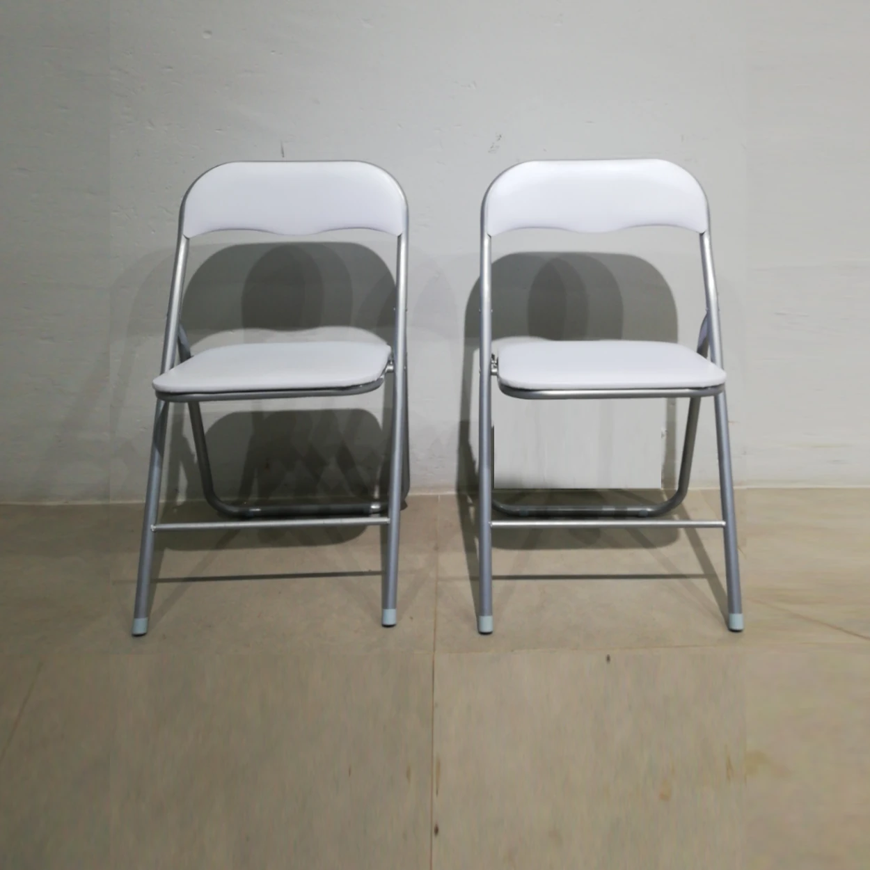 Cadira plegable amb entapissat blanc (44x39x79cm) procedent d'una empresa en tancament