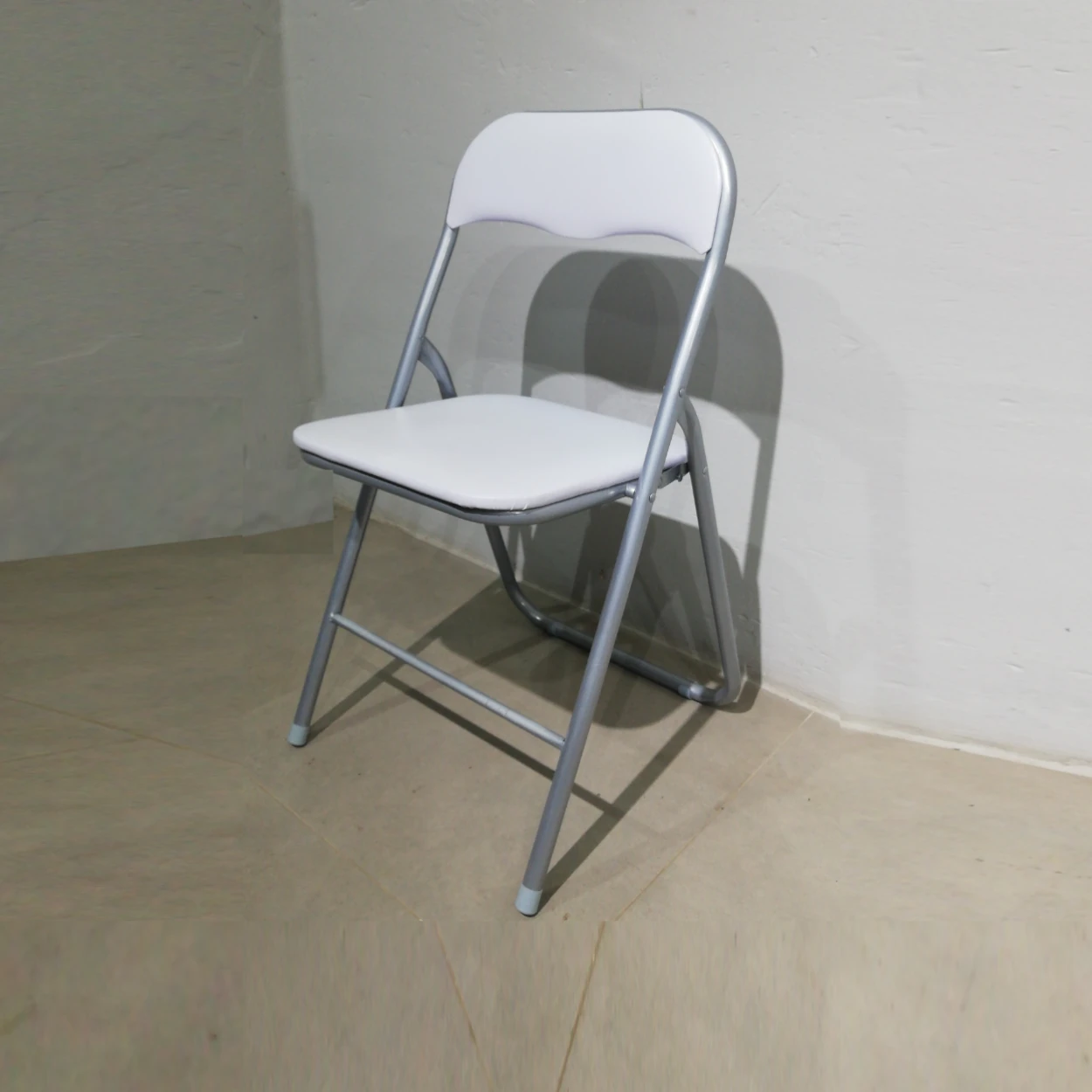 Cadira plegable amb entapissat blanc (44x39x79cm) procedent d'una empresa en tancament