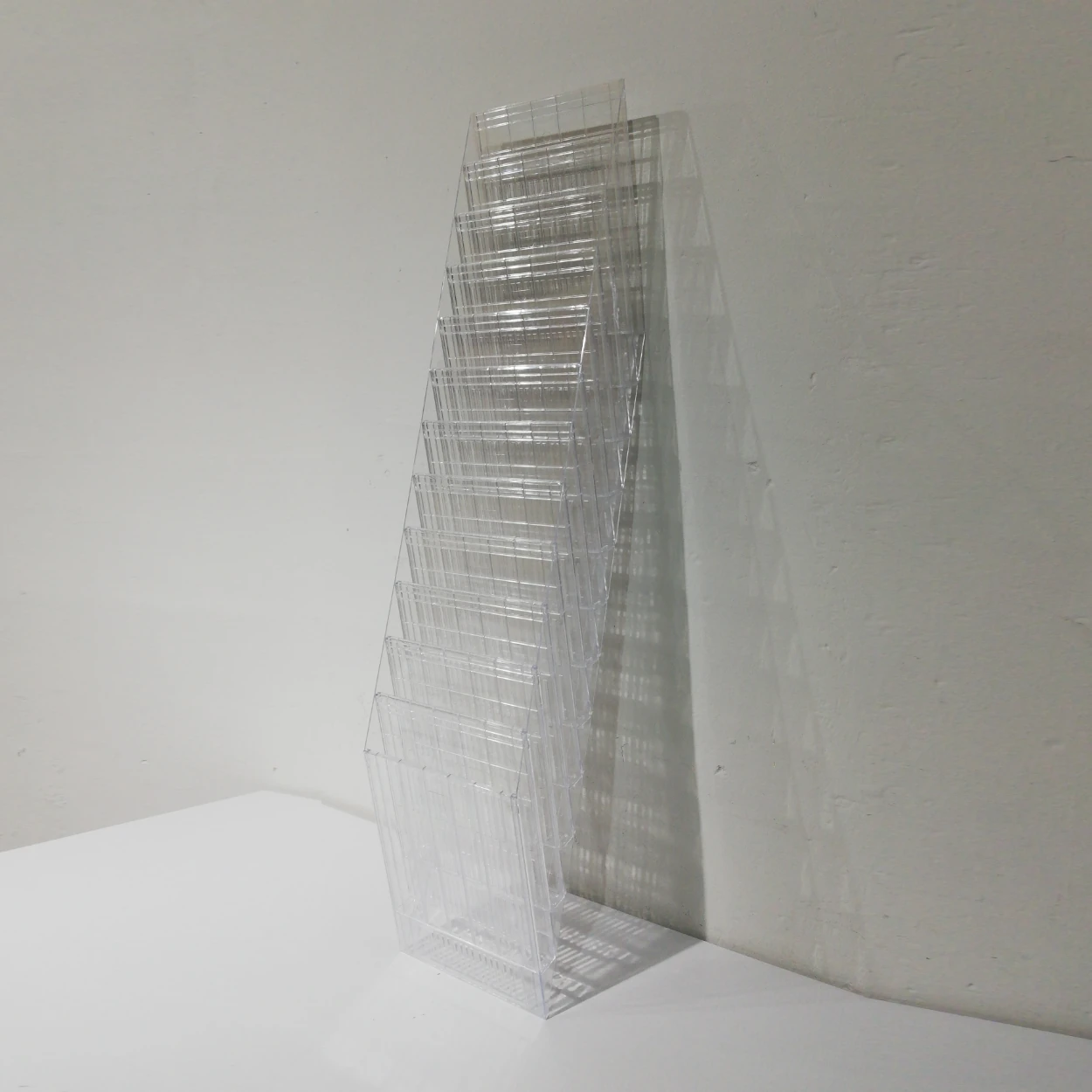 Dispensador de paret (24x13x112cm) fet de plร stic transparent amb 12 compartiments