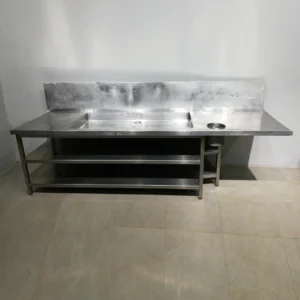 Taula de treball (300x85x129cm) d'acer inoxidable amb prestatgeria inferior i aigüera